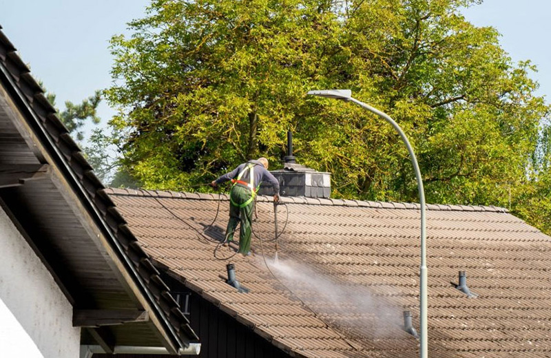 soft-wash Man soft washing a roof